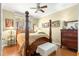 Cozy bedroom with a four poster bed and hardwood floors at 13885 Del Webb Blvd, Summerfield, FL 34491