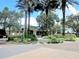 Landscaped entry to the clubhouse with palm trees, and ample parking at 13885 Del Webb Blvd, Summerfield, FL 34491