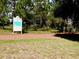 Picturesque conservation trail with sign, surrounded by lush greenery and tall trees at 13885 Del Webb Blvd, Summerfield, FL 34491