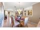 Open concept dining area featuring a glass table, elegant chairs, with a clear view into the living room at 13885 Del Webb Blvd, Summerfield, FL 34491
