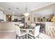 Dining area features a round table, white chairs, and decorative light fixture at 13885 Del Webb Blvd, Summerfield, FL 34491