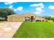 Charming single-story home featuring a three-car garage and manicured lawn with beautiful landscaping and plenty of curb appeal at 13885 Del Webb Blvd, Summerfield, FL 34491