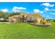 Well maintained yard featuring decorative stone retaining wall and meticulously manicured landscaping surrounding the home at 13885 Del Webb Blvd, Summerfield, FL 34491