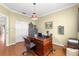 The home office features a wood desk, hardwood floors, closet, and natural light at 13885 Del Webb Blvd, Summerfield, FL 34491