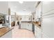 Kitchen with granite counters, stainless steel refrigerator, island, and white cabinetry at 13885 Del Webb Blvd, Summerfield, FL 34491