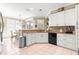 Bright kitchen with stainless steel appliances, granite countertops, and white cabinets at 13885 Del Webb Blvd, Summerfield, FL 34491
