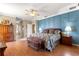Main bedroom featuring a blue accent wall and hardwood floors at 13885 Del Webb Blvd, Summerfield, FL 34491