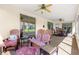 Relaxing outdoor patio featuring comfortable chairs, ceiling fans, and views of the landscaped backyard at 13885 Del Webb Blvd, Summerfield, FL 34491