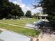 Shuffleboard courts surrounded by green grass and a pathway leading to a clubhouse at 13885 Del Webb Blvd, Summerfield, FL 34491