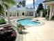 Outdoor spa with tiled patio, lush landscaping and covered pergola at 13885 Del Webb Blvd, Summerfield, FL 34491