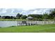 Scenic view of a lake with a charming gazebo on a pier, surrounded by lush greenery at 13885 Del Webb Blvd, Summerfield, FL 34491