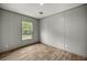 This is a bedroom featuring wood-look floors, a window, and neutral gray walls at 16231 Sw 20Th Ln, Ocala, FL 34481