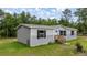 Charming home with neatly manicured lawn and stairs leading to the front door at 16231 Sw 20Th Ln, Ocala, FL 34481