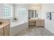 Bright bathroom features double sink vanity, soaking tub, glass block window, and neutral colors at 17755 Se 117Th Cir, Summerfield, FL 34491