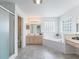 Bright bathroom features double sink vanity, soaking tub, glass block window, and step-in shower at 17755 Se 117Th Cir, Summerfield, FL 34491