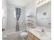 Bathroom features tub with shower, functional vanity, and modern shelving at 17755 Se 117Th Cir, Summerfield, FL 34491