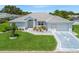 Charming single-story home with light blue exterior, well-manicured lawn and a two car garage on a sunny day at 17755 Se 117Th Cir, Summerfield, FL 34491