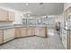 Open kitchen with light cabinets, tile floors, breakfast bar, and lots of natural light at 17755 Se 117Th Cir, Summerfield, FL 34491