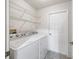 Functional laundry room with washer, dryer, and storage shelves for added convenience at 17755 Se 117Th Cir, Summerfield, FL 34491
