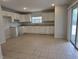 Bright kitchen with tiled flooring, ample cabinet space, and modern white appliances at 17974 Se 115Th Cir, Summerfield, FL 34491