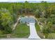 A lovely one story home with a spacious lawn and driveway, nestled among towering pines in a lush green landscape at 23163 Nw Shamrock Ave, Dunnellon, FL 34431