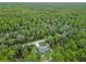 An aerial perspective of a home surrounded by lush green trees in a serene, wooded environment at 23163 Nw Shamrock Ave, Dunnellon, FL 34431