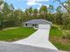 Aerial view of a house with a long driveway and green grass in the front yard at 23163 Nw Shamrock Ave, Dunnellon, FL 34431