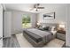 Cozy bedroom features neutral colors, ceiling fan, and large window offering views of the serene outdoor landscape at 23163 Nw Shamrock Ave, Dunnellon, FL 34431