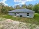 Back exterior view of the house with a sliding door, windows and an HVAC system at 23163 Nw Shamrock Ave, Dunnellon, FL 34431