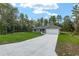 A single-story home with a well-manicured lawn, long concrete driveway, and an attached two-car garage at 23163 Nw Shamrock Ave, Dunnellon, FL 34431