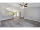 Open living space featuring vaulted ceilings, gray wood-look flooring, and natural light at 23163 Nw Shamrock Ave, Dunnellon, FL 34431