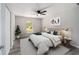 The light and airy main bedroom features stylish decor, a ceiling fan and view of surrounding woods at 23163 Nw Shamrock Ave, Dunnellon, FL 34431