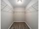 This walk-in closet features hanging racks, shelving, and modern wood laminate flooring for optimal storage solutions at 23163 Nw Shamrock Ave, Dunnellon, FL 34431