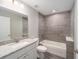 Stylish bathroom features a granite vanity top, tiled shower over tub, and contemporary fixtures at 24144 Nw Water Oak Ave, Dunnellon, FL 34431