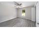 Bedroom features neutral paint, wood flooring, a ceiling fan, and a large window with natural light at 24144 Nw Water Oak Ave, Dunnellon, FL 34431