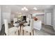 Bright dining area featuring seating for four, modern light fixture, and an open connection to kitchen at 24144 Nw Water Oak Ave, Dunnellon, FL 34431
