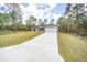 Charming one-story home featuring a long driveway, a two-car garage, and manicured front yard at 24144 Nw Water Oak Ave, Dunnellon, FL 34431