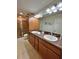 Well-lit bathroom includes a dual sink vanity and a glass door shower at 3023 Charlevoix St, The Villages, FL 32163