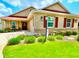 Charming single-story home featuring a well-manicured lawn and colorful landscaping with red shutters, and a red roof at 3023 Charlevoix St, The Villages, FL 32163
