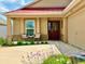 Inviting front entrance with cozy seating area, beautiful plants, and an attractive front door at 3023 Charlevoix St, The Villages, FL 32163