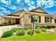 Charming single-story home featuring a well-manicured lawn and colorful landscaping with red shutters, and a red roof at 3023 Charlevoix St, The Villages, FL 32163