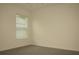 An empty bedroom featuring neutral walls, plush carpet, and a bright window at 356 Se 66Th Ct, Ocala, FL 34472