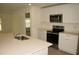 Modern kitchen featuring white cabinets, a stainless steel microwave, a range, and an island with a sink at 356 Se 66Th Ct, Ocala, FL 34472