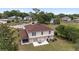 Backyard view of a two-story home with a patio, dining table, grill, and green space at 4620 Sw 42Nd St, Ocala, FL 34474