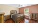Bright bedroom featuring wood floors, ceiling fan, and a window overlooking the yard at 4620 Sw 42Nd St, Ocala, FL 34474