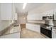 Well-lit kitchen with stainless steel appliances, granite countertops, white cabinets, and tile flooring at 4886 Nw 30Th Pl, Ocala, FL 34482