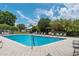 Community pool area surrounded by trees and lounge chairs at 4886 Nw 30Th Pl, Ocala, FL 34482