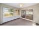 Enclosed lanai features neutral carpet, ceiling fan, and large sliding glass doors at 4886 Nw 30Th Pl, Ocala, FL 34482