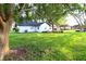Expansive backyard with lush green lawn and mature trees providing shade, offering a serene outdoor space at 5351 Sw 80Th Pl, Ocala, FL 34476