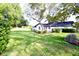 Back view of home with expansive, well-maintained lawn and landscaping at 5351 Sw 80Th Pl, Ocala, FL 34476